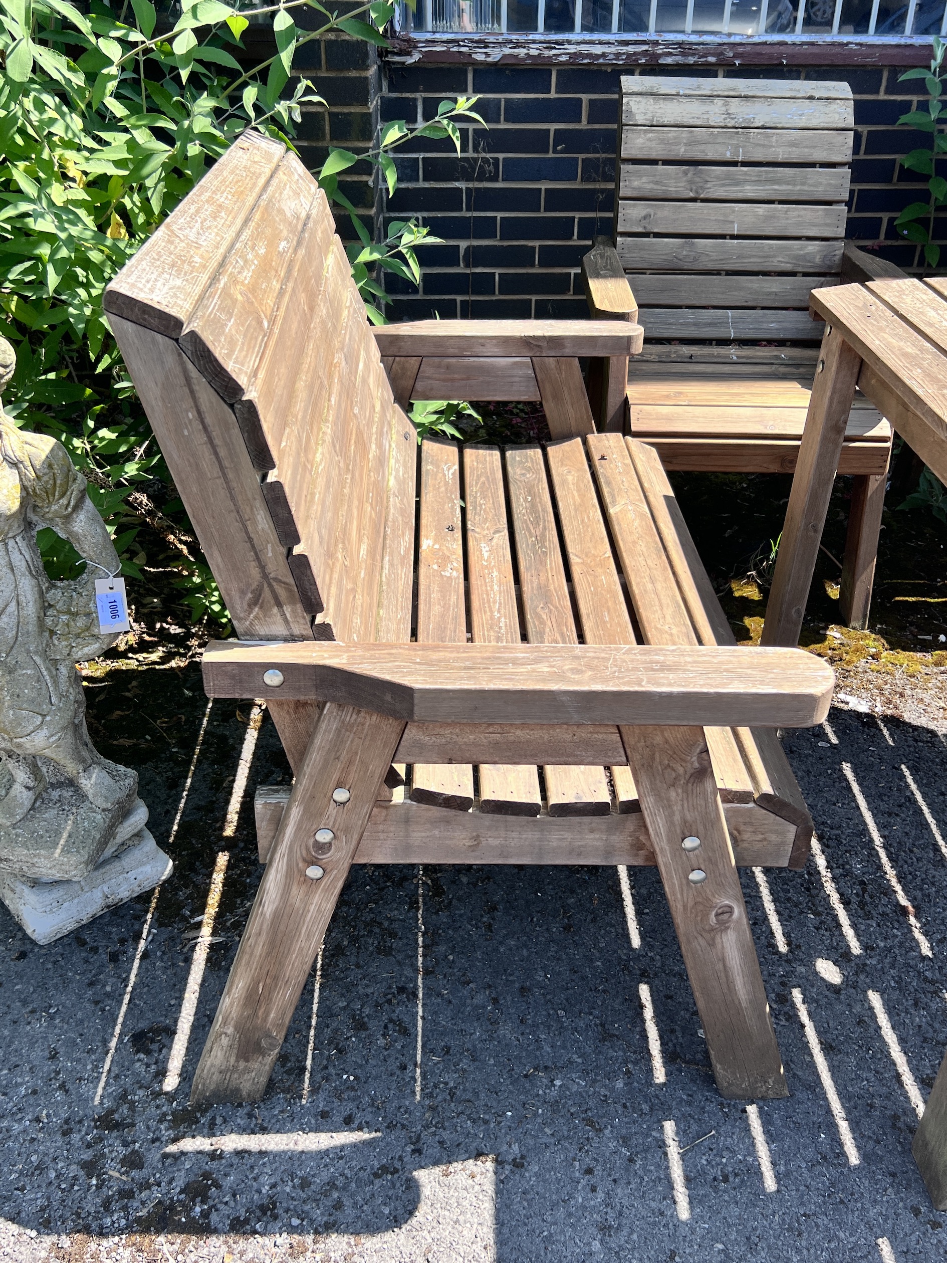 A rectangular slatted teak garden table, length 130cm, width 96cm, height 79cm, together with a pair of armchairs and a pair of benches